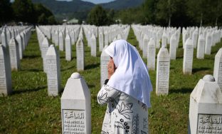 A woman prays at a graveyard, ahead of a mass funeral in Potocari near Srebrenica, Bosnia and Herzegovina July 11, 2020. Bosnia marks the 25th anniversary of the massacre of more than 8,000 Bosnian Muslim men and boys, with many relatives unable to attend due to the coronavirus disease (COVID-19) outbreak. REUTERS/Dado Ruvic