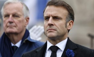 FILE - French President Emmanuel Macron, right, and Prime Minister Michel Barnier stand at attention during commemorations marking the 106th anniversary of the November 11, 1918, Armistice, ending World War I, at the Arc de Triomphe in Paris, Monday, Nov. 11, 2024. ( Ludovic Marin, Pool via AP, File)
