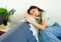 Upset young woman feeling lonely and depressed while sitting on a sofa at home and holding a smartphone; Shutterstock ID 2539602391; purchase_order: Psychologies; job: Digital