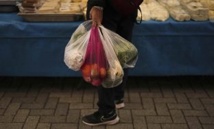 A woman buys groceries at the Fener street food market, in Istanbul, Turkey, Tuesday, April 8, 2025. (AP Photo/Francisco Seco)